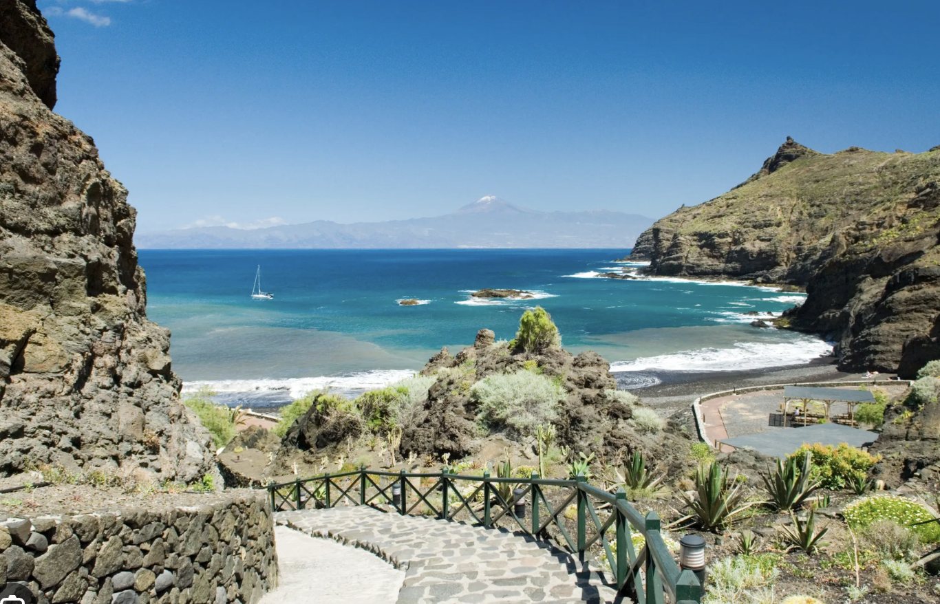 A stone path down to a cove, with Mount Teide across the water