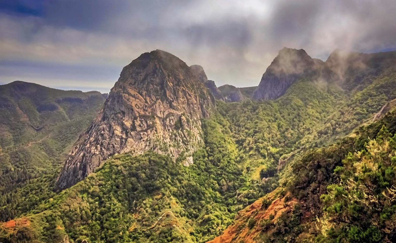Rock peaks rising above green, misty valleys